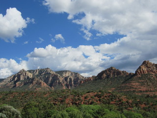 View of red rock mountains near Sedona, Arizona with clouds and blue sky in the background 