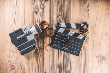 Cinema movie clapperboard and retro camera with filmstrip
