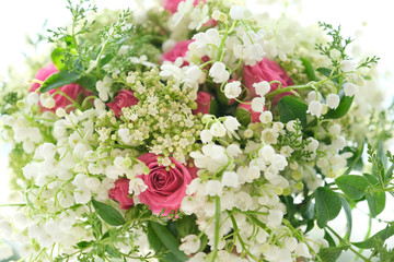 Close-up of pink roses flowers and white lily of the valley with drops