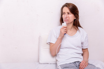 The concept of coronavirus quarantine. Young woman in isolation at home makes inhalation. Theme of health and medicine. Medical virus poster design. Free space for text