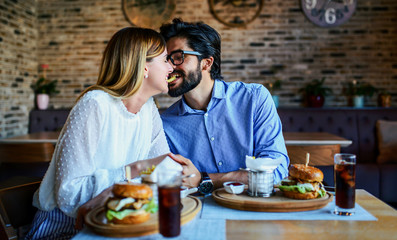 Young couple sitting in a cafe, having breakfast. Love, dating, food, lifestyle concept