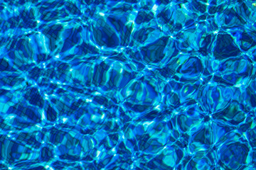 Blue background with lots of light spots. Sun glare in the pool	