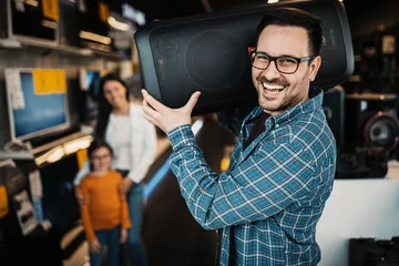 Photo sur Plexiglas Magasin de musique Famille heureuse achetant un grand haut-parleur de musique dans un magasin de technologie.
