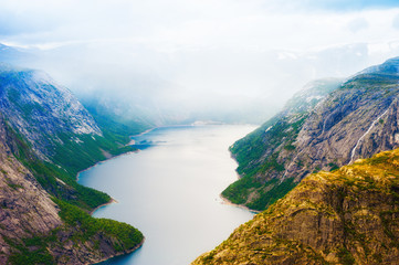 Lake in the mountains in foggy morning, Norway. Ringedalsvatnet lake on the hiking trek to Trolltunga. Summer landscape