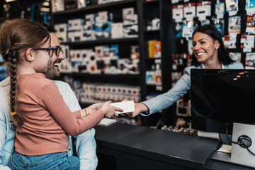 Father and daughter buying in tech store.