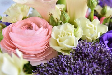 Bouquet of spring flowers with beautiful pink ranunculus flower, fluffy purple plants, white roses and violet Alstroemeria flowers. Soft focus. Spring time 