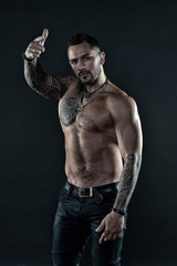 brutal and sexy. muscular bodybuilder with body tattoo. athletic male show six packs on torso....