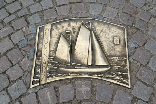 GDANSK, POLAND - AUGUST 10, 2017: A metal plate with an image of a sailing boat on a bar bridge. Polish text - corsar