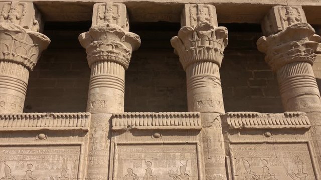 Hieroglyphic carvings on the exterior walls of an ancient egyptian temple, tilt view 4k