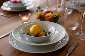 Easter table setting composition with traditional golden painted egg, beautiful tableware on natural dark wood textured table. Top view, copy space, close up, background.
