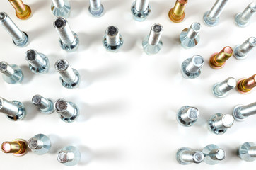 on a white background close-up new shiny nuts and bolts of a car top view