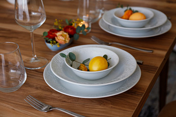 Easter table setting composition with traditional golden painted egg, beautiful tableware on natural dark wood textured table. Top view, copy space, close up, background.