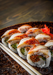 sushi roll with cream cheese and eel in plate on wooden table background