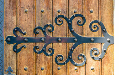 Door hinge vintage decoration on outer side of entrance door. Frequently used in christian culture.
