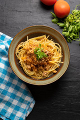 Spaghetti bolognese with parmesan cheese on dark background