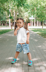 little smiling girl model in white shirt phaving fun in park