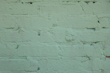 abstract background of an old brick wall painted light green close up