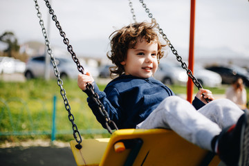 Funny cute happy baby playing on the playground. The emotion of happiness, fun, joy. Smile of a child.