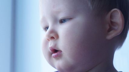 Face of a 1 year old boy in close-up on a light background