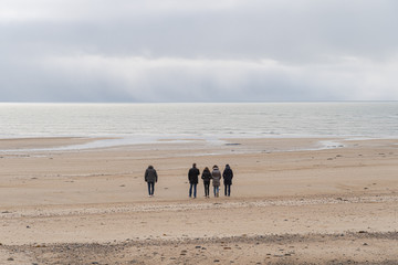 Agon-Coutainville, France - 12 30 2018: Walkers on Pointe d'Agon Beach at Sunset