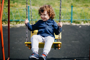 Funny cute happy baby playing on the playground. The emotion of happiness, fun, joy. Smile of a child.