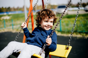 Funny cute happy baby playing on the playground. The emotion of happiness, fun, joy. Smile of a child.