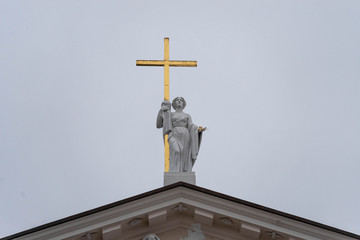 sculpture of a woman with a cross