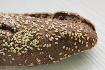Dark rye bread with sesame seeds and flax on the table. Close-up.