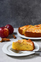 Piece of apple pie on a white plate food flat lay. homemade pie recipe. home food delivery during coronavirus COVID-19. on a concrete background top view