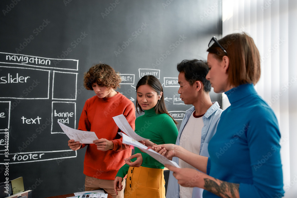 Canvas Prints young professionals. group of four web designers in casual wear developing new web site layout while