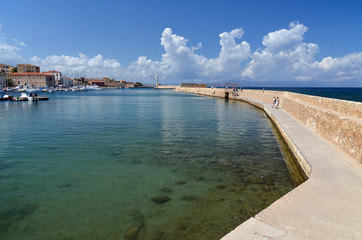 View of the port of Chania and the lighthouse surrounded by clear water, second largest city of Crete island, Greece.