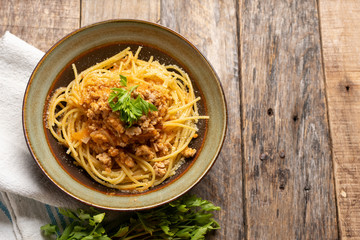 Spaghetti bolognese with parmesan cheese on wooden background