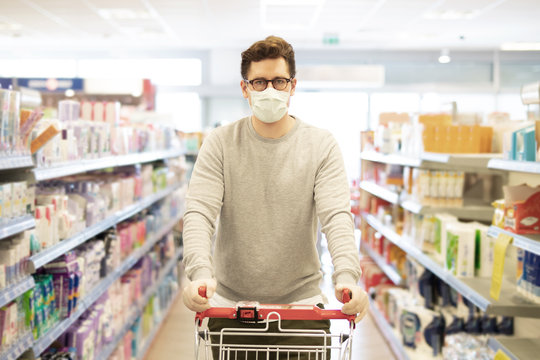 Coronavirus, Mann schützt sich im Laden mit Atemmaske und Handschuhen vor einer Ansteckung