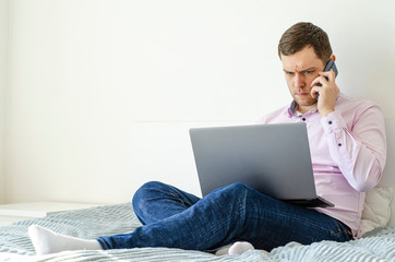 Coronavirus. Quarantine. A man in a shirt and jeans solves work issues remotely.