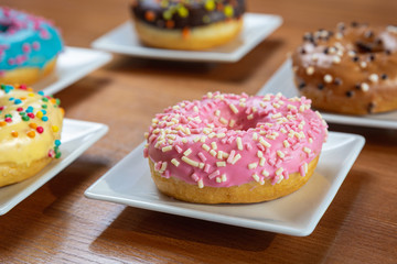 Pink glazed donut  on a white plate