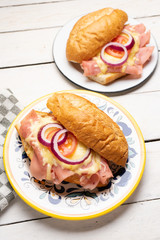 Mexican ham sandwich with melted cheese also called torta on white background