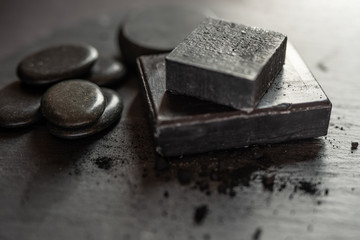 Black carbon charcoal soap on a black granit background 