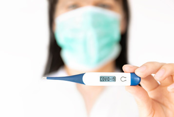 A women nurse holding thermometer. Medical concept of coronavirus outbreak.