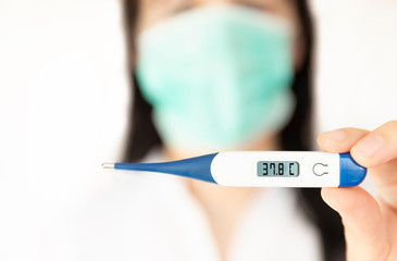 A women nurse holding thermometer. Medical concept of coronavirus outbreak.