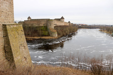 Fototapeta na wymiar View to impregnable russian fortress Ivangorod from bastions of Narva Hermann castle with wall of the tower on the left