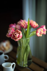 Bouquet of pink tulips. Bouquet of flowers in a vase. Bouquet of flowers in the morning sun beams. Pink tulips in a transparent glass vase
