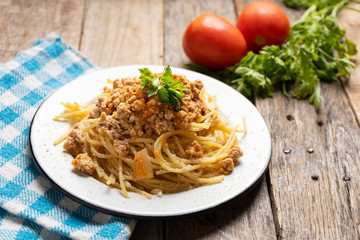 Spaghetti bolognese with parmesan cheese on wooden background