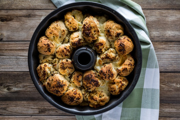 Top down view of a bundt pan filled with freshly baked pull apart rolls ready for eating. Also known as monkey bread.