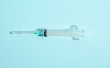 Syringe on the blue background. Single medicine object on the blue background with copy space.