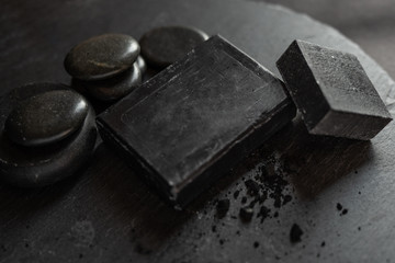 Black carbon charcoal soap on a black granit background 