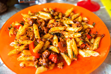Italian pasta bolognese served on orange plate