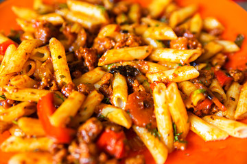 Italian pasta bolognese served on orange plate