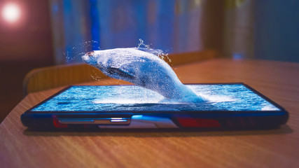 Photo manipulation of a whale jumping through the screen of mobile phone.