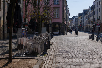 Fototapeta premium Empty street with closing shop, cafe and restaurant during quarantine from contagion of COVID-19 on walking street and plaza in old town in Düsseldorf, Germany.