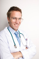 Portrait of smiling doctor in white lab coat and stethoscope with arms folded